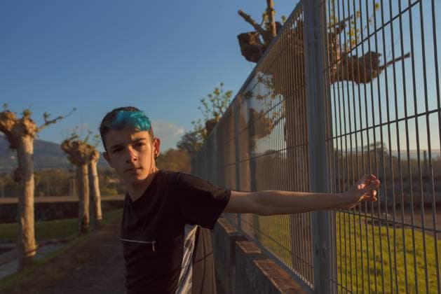Tired teenager leaning on fence in park, Model released Copyright: xAlbertoxMenendezx MR