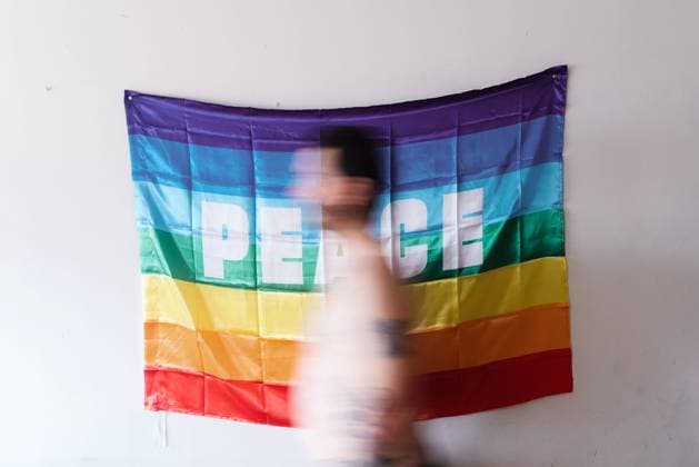 young Caucasian boy passing in front of a rainbow flag of peace., Model released Copyright: xAlbertoxMenendezx MR