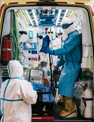 Group of professional doctors in protective uniform standing in ambulance car with equipment and preparing for patient transportation, Model released Copyright: xAparicioxFebrerx MR