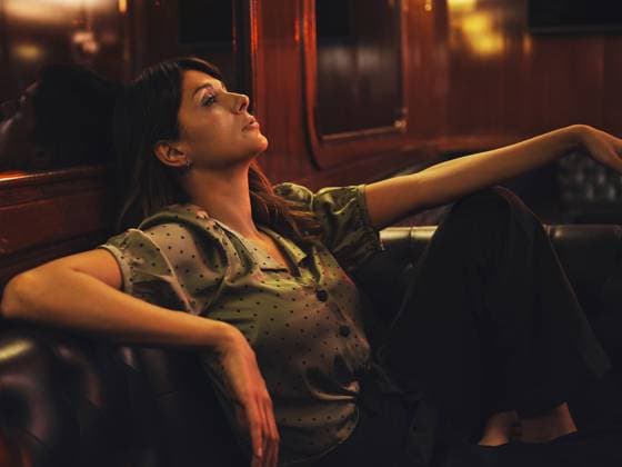IMAGO Creative: Internationaler Frauentag, Mental Load und Care-Arbeit Side view of tired relaxed woman leaning on back of leather black sofa and looking away in cafe Copyright: xCienxXxCienxStudiox Model Released