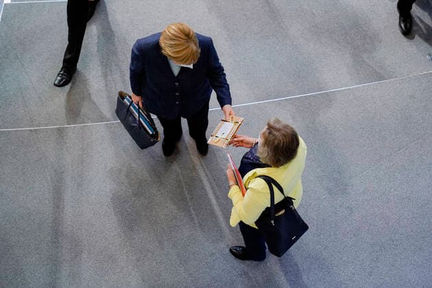 201. Bundestagssitzung in Berlin (Plenum und Debatte) Aktuell, 16.12.2020, Berlin, Angela Merkel die Bundeskanzlerin der Bundesrepublik Deutschland erhaelt ein Weihnachtsgeschenk einer Abgeordneten auf dem Weg aus dem Plenarsaal nach der Debatte zum Thema Befragung der Bundesregierung bei der 201. Sitzung des Deutschen Bundestag in Berlin Berlin Berlin Deutschland *** 201 Bundestag session in Berlin Plenary and debate Current, 16 12 2020, Berlin, Angela Merkel the Chancellor of the Federal Republic of Germany receives a Christmas gift from a member of parliament on her way out of the plenary chamber after the debate on the issue questioning the federal government at the 201 session of the German Bundestag in Berlin Berlin Germany