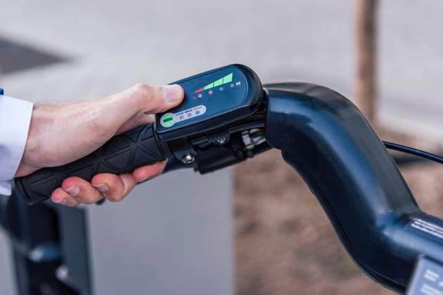 IMAGO Creative: Corporate: Klimaschutz, Digitalisierung und Urbanisierung From above of crop anonymous male touching LCD display with colorful symbols on electric bicycle Copyright: xDavidxEspejox Model Released