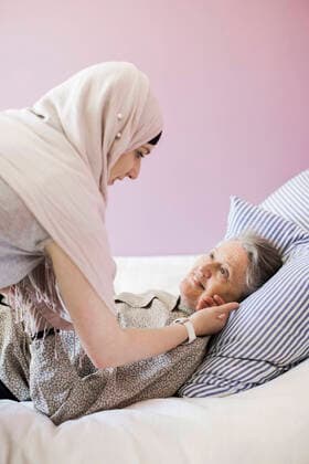 Young female home caregiver assisting senior woman in bed , model released Copyright: xMaskotx , MA37414