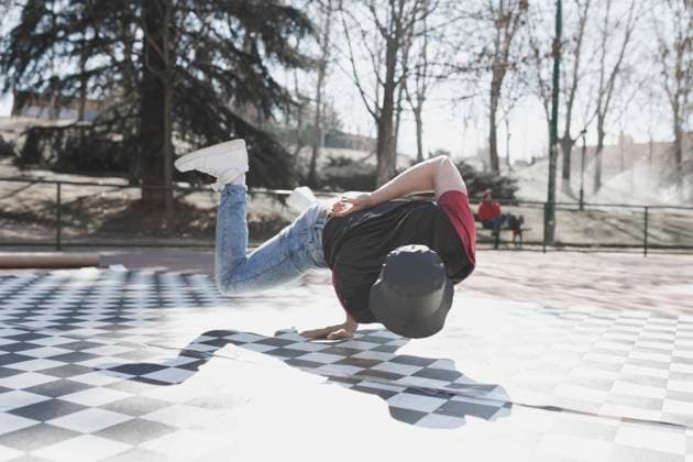 Young athletic guy practicing break dance in park in sunny weather Copyright: xDavidxGailx Model Released