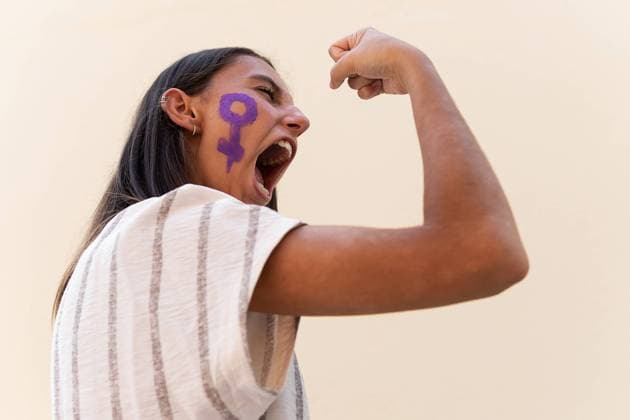 IMAGO Creative: Gesellschaft, Integration Side view low angle of determined female with gender symbol on face demonstrating muscles while showing girl power concept Copyright: xDavidxMunozx Model Released
