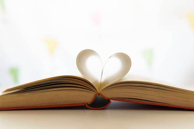 Closeup of opened book with pages in shape of heart placed on table in bright room Copyright: xDavidxMunozx Model Released