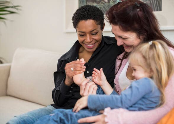 Happy lesbian couple with girl in living room , model released Copyright: xMaskotx , MA40871