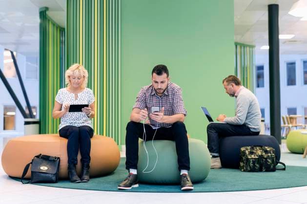Businesspeople using technologies at modern office lobby , model released Copyright: xMaskotx , MA43911