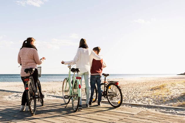 Full length of friends with bicycles on boardwalk at beach , model released Copyright: xKentarooxTrymanx , MA47025