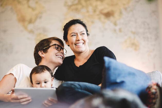 Smiling lesbian couple and baby girl with digital tablet at home , model released Copyright: xMaskotx , MA49061