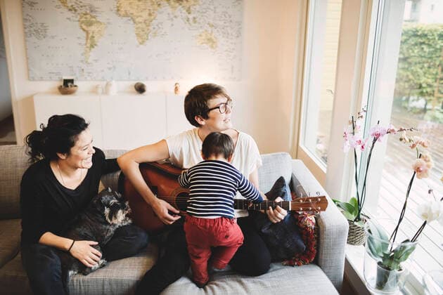 Mother and daughter playing guitar while smiling woman with dog at home , model released Copyright: xMaskotx , MA49071