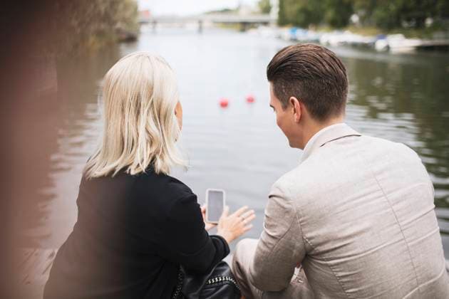 IMAGO Creative, Jahreszeit Sommer, Sommer in der Stadt Rear view of business people discussing mobile phone against lake , model released, property released Copyright: xMaskotx , MA54045