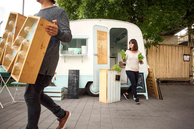 Owners carrying letter M and potted plants while walking outside food truck on street , model released, property released Copyright: xMaskotx , MA54313