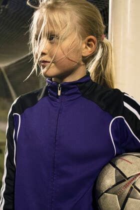 Girl holding soccer ball looking away while standing by goal post , model released Copyright: xMaskotx , MA55642