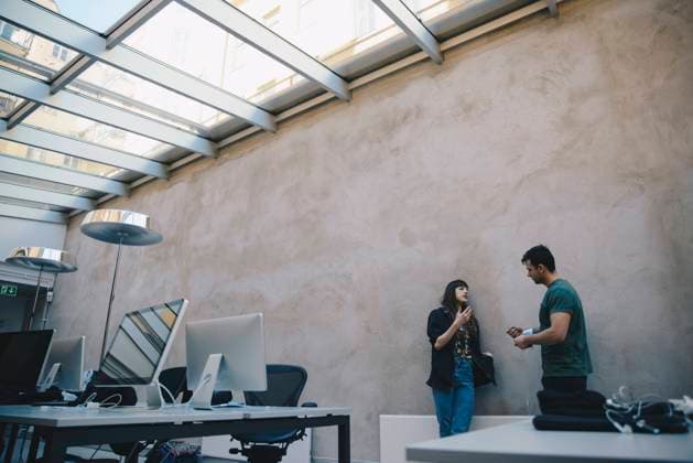 Low angle view of computer programmers discussing against wall in office , model released, property released Copyright: xMaskotx , MA56920