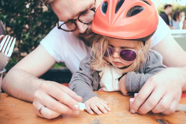 IMAGO Creative, Urban Lifestyle Father painting daughter s nails at table outdoors , model released Copyright: xMaskotx , MA57368