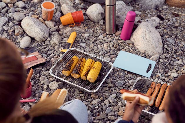 High angle view of woman and daughter preparing food on barbecue grill at beach , model released Copyright: xMaskotx , MA57694