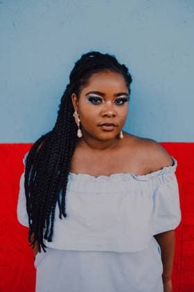IMAGO Creative: Clickbait, Modetrends Attractive modern young black young woman with bright make-up in off-shoulder dress standing looking at camera Copyright: xGenessaxPanaintex Model Released