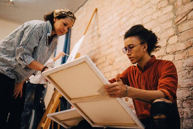 IMAGO Kreativ: Bildung, Kunsterziehung Low angle view of female trainer with artist at art studio , model released, property released Copyright: xMaskotx , MA62186
