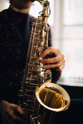 IMAGO Creative: Bildung, Musikerziehung Midsection of woman playing saxophone at studio , model released, property released Copyright: xMaskotx , MA62213