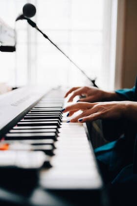 IMAGO Creative: Bildung, Musikerziehung Cropped image of woman playing piano by window at studio , model released, property released Copyright: xMaskotx , MA62247