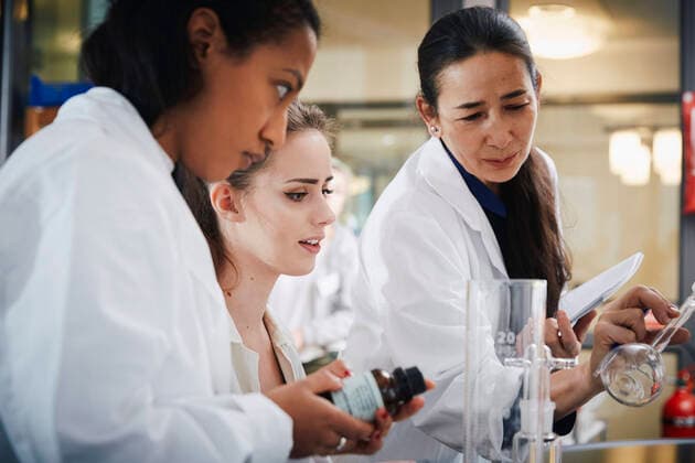 Mature teacher with young female students learning chemistry at laboratory , model released, property released Copyright: xMaskotx , MA62654