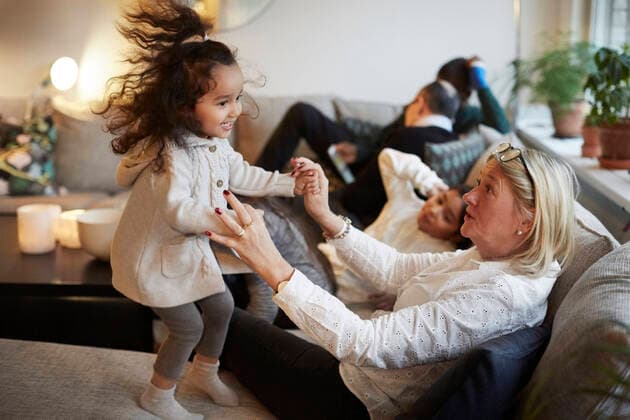 Girl playing with grandmother on sofa by family at home , model released, property released Copyright: xMaskotx , MA62686