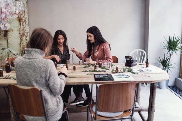 IMAGO Kreativ: Bildung, Kunsterziehung Female colleagues preparing perfume while sitting at table in workshop , model released, property released Copyright: xMaskotx , MA62716