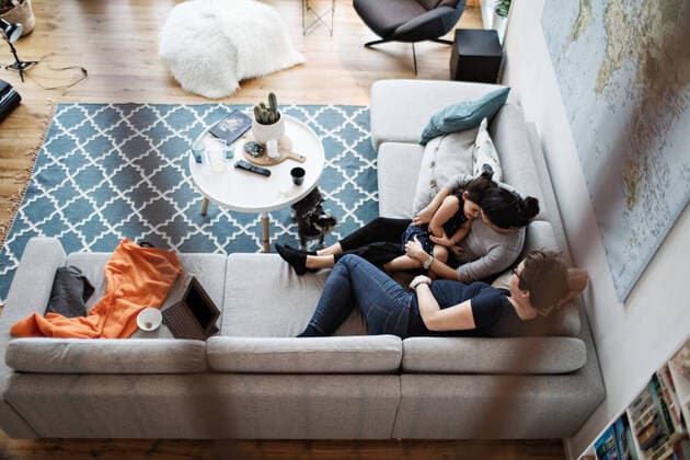 High angle view of lesbian couple talking with daughter while sitting on sofa by dog in living room at home , model released, property released Copyright: xMaskotx , MA63053