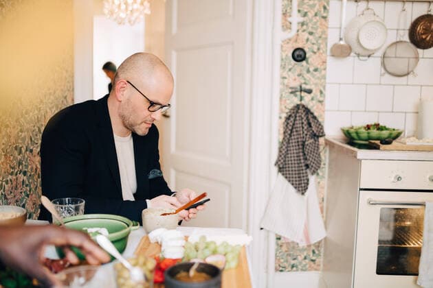 IMAGO Creative: Landleben - Essen Mature man using mobile phone while sitting at dining table during party , model released, property released Copyright: xMaskotx , MA65149