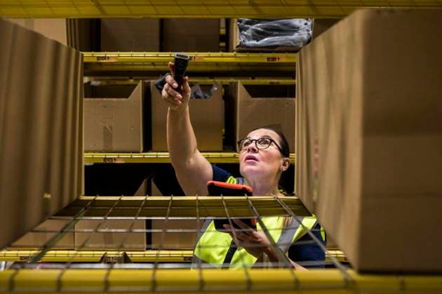 Mature female worker holding digital tablet and bar code reader against rack at distribution warehouse , model released, property released Copyright: xMaskotx , MA65215