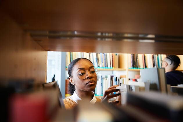 Male and female university students reading books in library , model released, property released Copyright: xMaskotx , MA65428