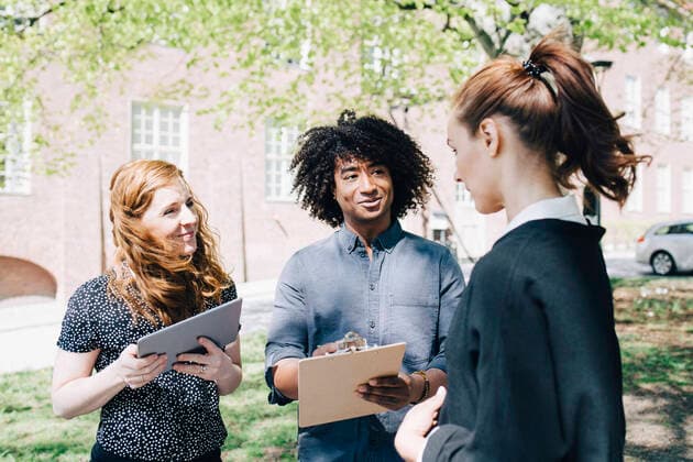 Confident businesswoman discussing with multi-ethnic colleagues while standing outdoors , model released, property released Copyright: xMaskotx , MA65720