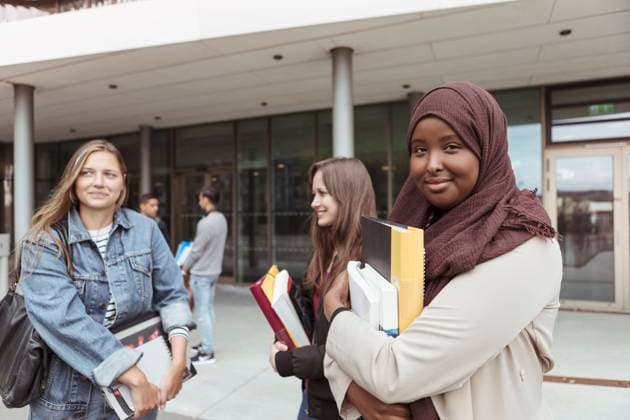 Portrait of student in hijab standing with friends at university campus , model released, property released Copyright: xKentarooxTrymanx , MA68375
