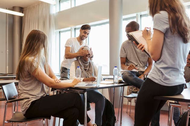 Man surprising female friend while covering eyes during project discussion in classroom , model released, property released Copyright: xKentarooxTrymanx , MA68397