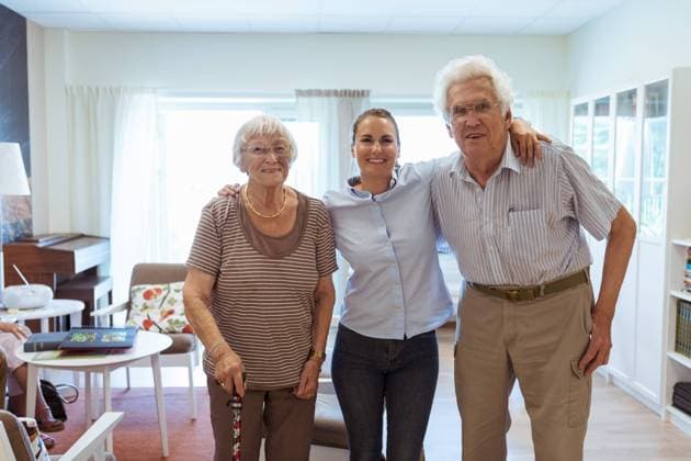 Portrait of smiling young woman with grandparents standing together in nursing home , model released, property released Copyright: xKentarooxTrymanx , MA68807