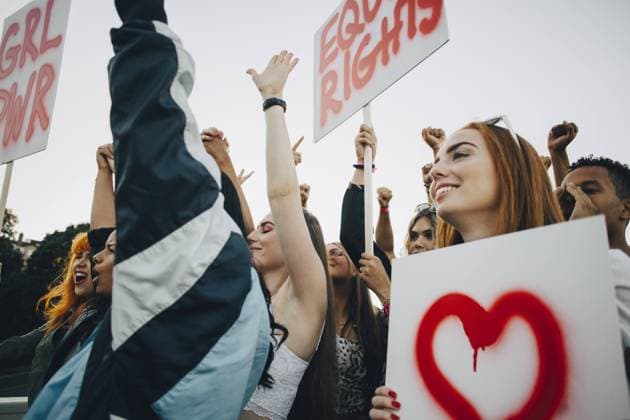 IMAGO Creative: Frauenmonat, Feministischer Aktivismus Low angle view of smiling women protesting with banners in city , model released Copyright: xMaskotx , MA69765