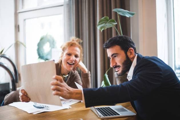 Smiling female illustrator showing drawing to male entrepreneur at office , model released, property released Copyright: xMaskotx , MA70110