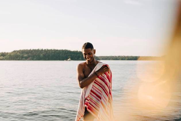 Smiling man wiping with towel after swimming in lake , model released Copyright: xMaskotx , MA70422