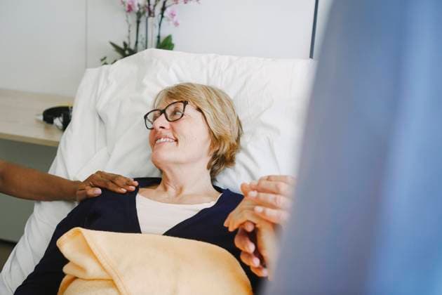 IMAGO Creative: Brustkrebsmonat Senior woman looking at encouraging doctor while holding partner s hands in ward at hospital , model released, property released Copyright: xMaskotx , MA72649