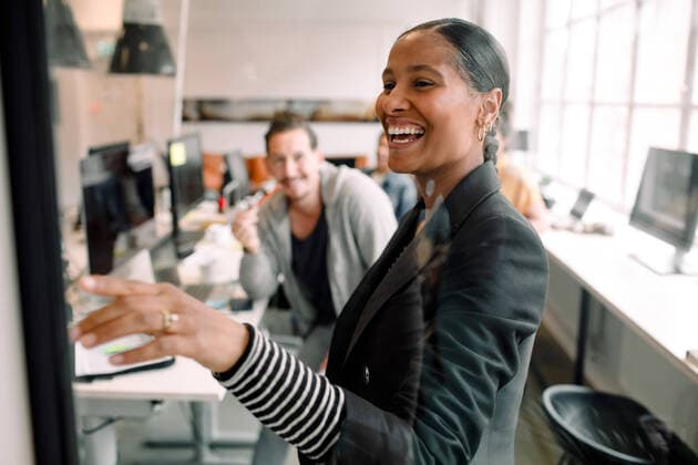 Smiling businesswoman discussing with coworker seen through glass at office , model released, property released Copyright: xMaskotx , MA73560