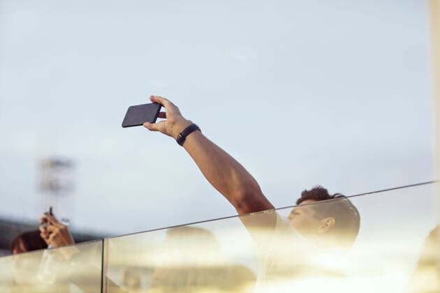 Low angle view of colleagues photographing through smart phone while enjoying in office party on terrace , model released, property released Copyright: xMaskotx , MA74826