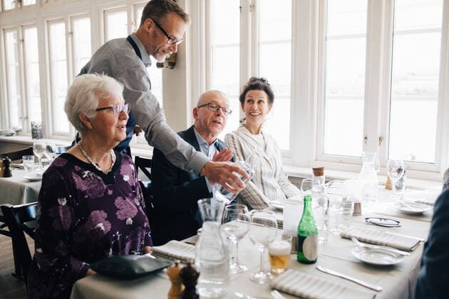 Owner serving water to senior people sitting at restaurant , model released, property released Copyright: xMaskotx , MA75082