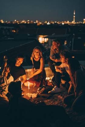High angle view of friends enjoying rooftop party on illuminated terrace in candlelight , model released, property released Copyright: xMaskotx , MA75518