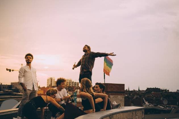 IMAGO Creative, Lifestyle, Leben in einer Wohngemeinschaft, WG IMAGO Kreativ: Urbane Kultur - Sommer auf den Dächern IMAGO Creative: Menschen in Berlin Man enjoying beer while relaxing with friends on terrace at rooftop party , model released, property released Copyright: xMaskotx , MA75602