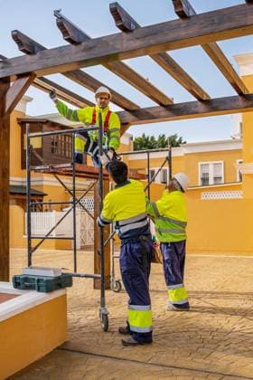 IMAGO Creative: Klimawandel - Zukunft und Innovation Group of male technicians in uniform working with alternative solar panels and preparing for installation near residential building Copyright: xJavierxDexLaxTorrex Model Released