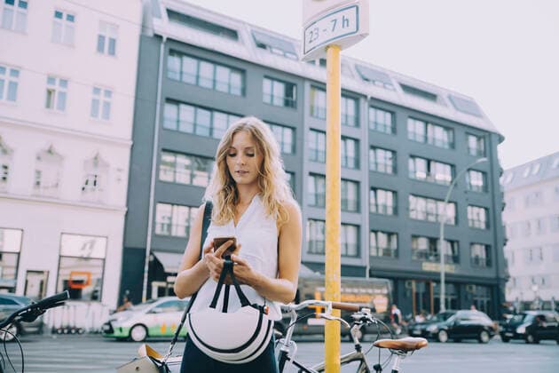 IMAGO Creative: Sport in der Stadt Young businesswoman using mobile phone while standing on street in city , model released Copyright: xMaskotx , MA77480