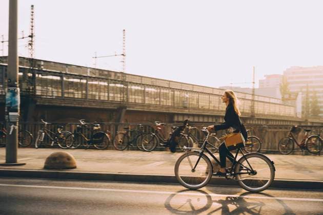 Full length of young businesswoman riding bicycle on street in city , model released Copyright: xMaskotx , MA77505