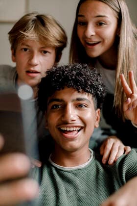 Smiling teenage boy taking selfie with friends through mobile phone at home Sweden, Stockholm, model released, property released Copyright: xMaskotx , MA78989