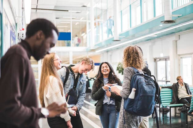 Cheerful young male and female students talking while standing in cafeteria at university Sweden, Stockholm, model released, property released Copyright: xMaskotx , MA79834